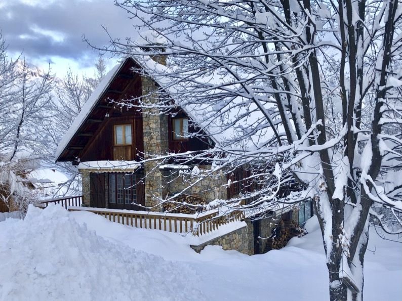 Le chalet derrière des branches enneigées